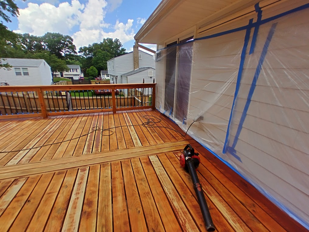Masking surfaces before deck staining service